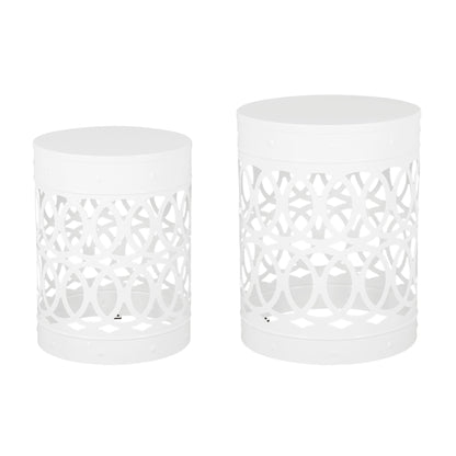 The Outdoor Metal S/2 End Table features two white, cylindrical tables with cut-out circular geometric patterns and solid tops, displayed side by side, with one table slightly taller and larger than the other.