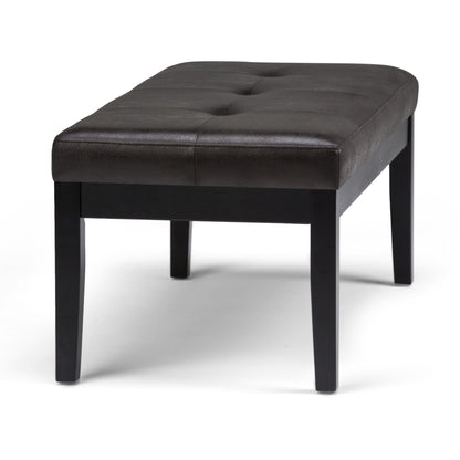 The Lacey Upholstered Tufted Ottoman Bench features a rectangular dark brown design with tufted buttons on top and four wooden legs, displayed against a plain white background.
