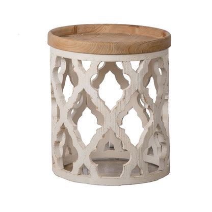 The Stylish Rustic Round Wooden Table features a light wooden top and a decorative white painted base with intricate cut-out patterns and a distressed rustic finish.