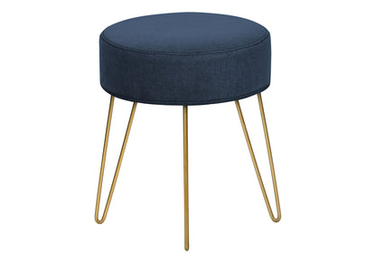 A contemporary round ottoman featuring dark blue upholstery, a cushioned top, and four slender gold metal legs, ideal as a pouf, footrest, or foot stool.