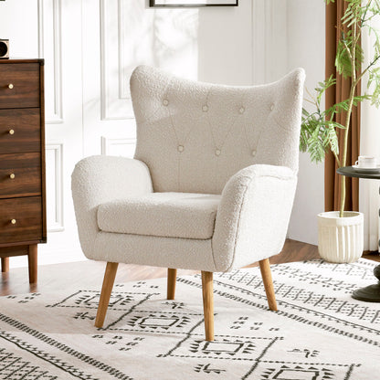 The Mid-Century Modern Arm Chair with wingback design and wood legs, upholstered in white, sits on a patterned rug in a bright room featuring white walls, a wooden dresser, round table, and potted plant.