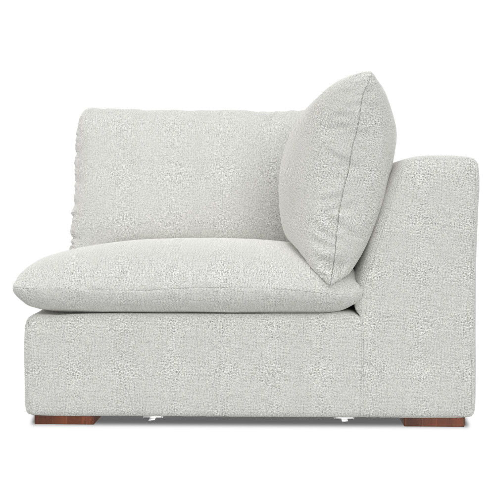 The Jasmine - Handcrafted Sofa and Ottoman features a light gray upholstered corner chair with thick, plush cushions and a low backrest, shown from the side against a white background.