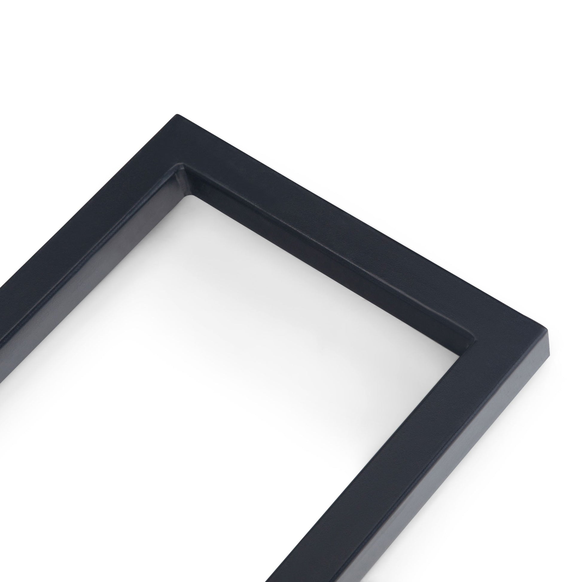 A close-up of the corner of the Skyler - C Side Handcrafted Table, showcasing its rectangular black frame against a white background.