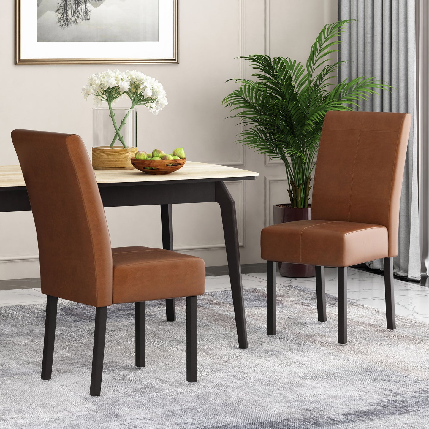 Two Pertica Dining Upholstered Armless Chairs with dark legs sit by a light wood table topped with apples and white flowers. The modern room also features a potted plant, gray curtains, and framed art.