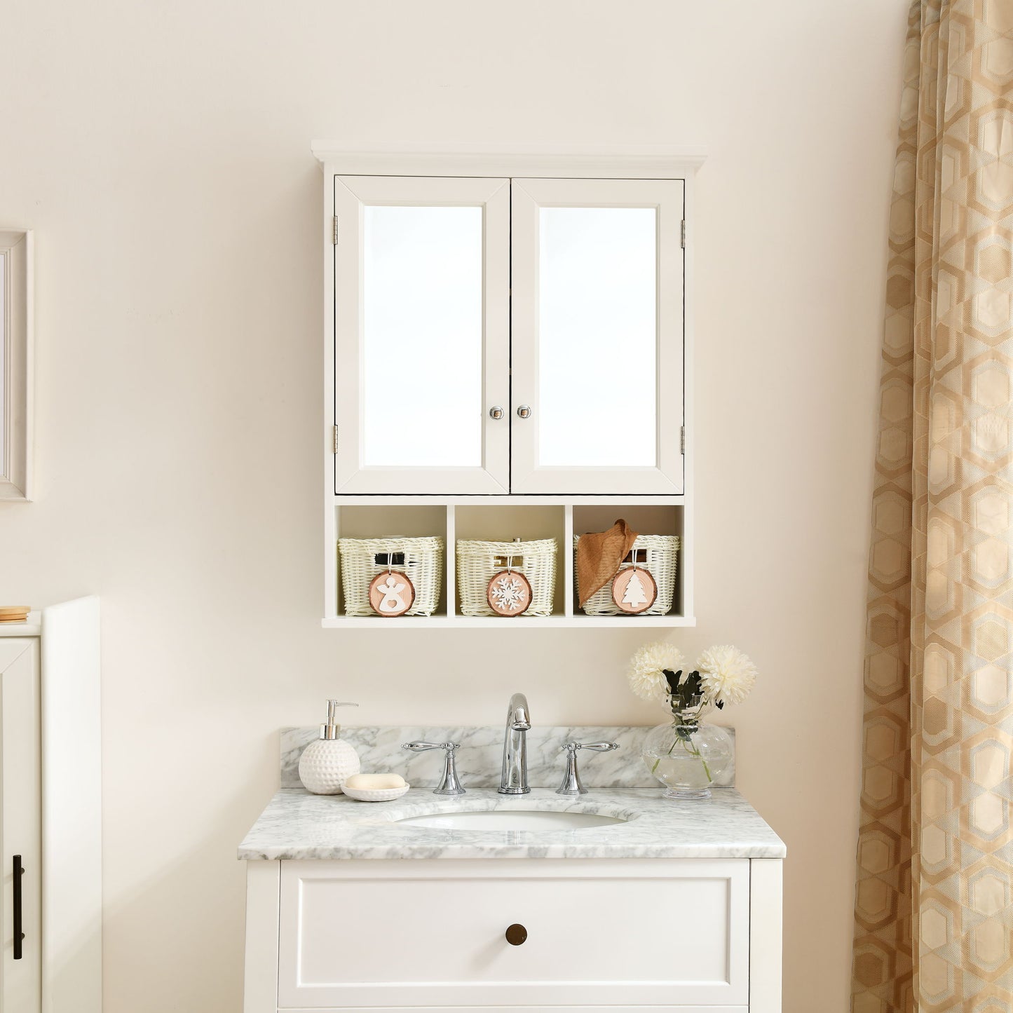 A white bathroom vanity with marble top, sink, and faucet sits below a mirrored medicine cabinet with two doors, adjustable shelves, and three Christmas-style storage baskets. Flowers and soaps decorate the countertop.