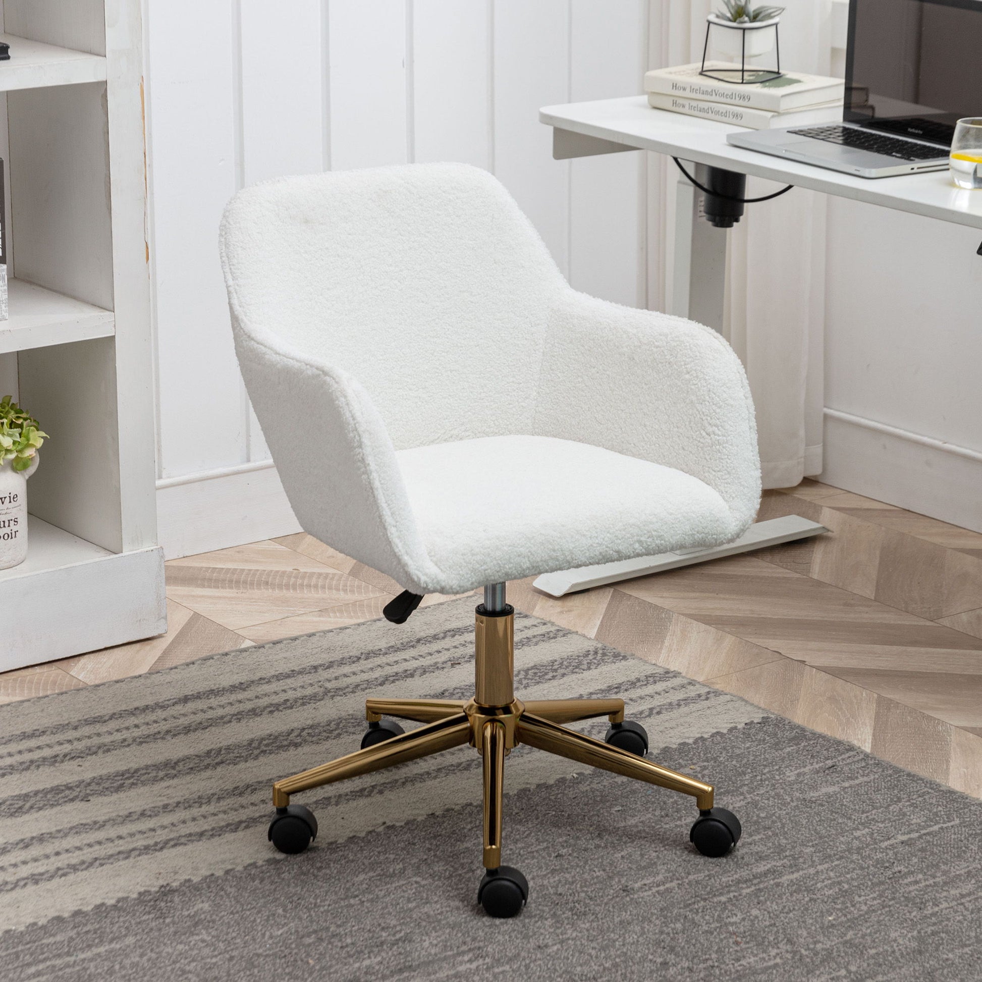 The Modern Adjustable Height 360 Revolving Home Office Chair with metal legs and universal wheels sits on a gray rug near a desk, books, and a small plant in a contemporary home office.