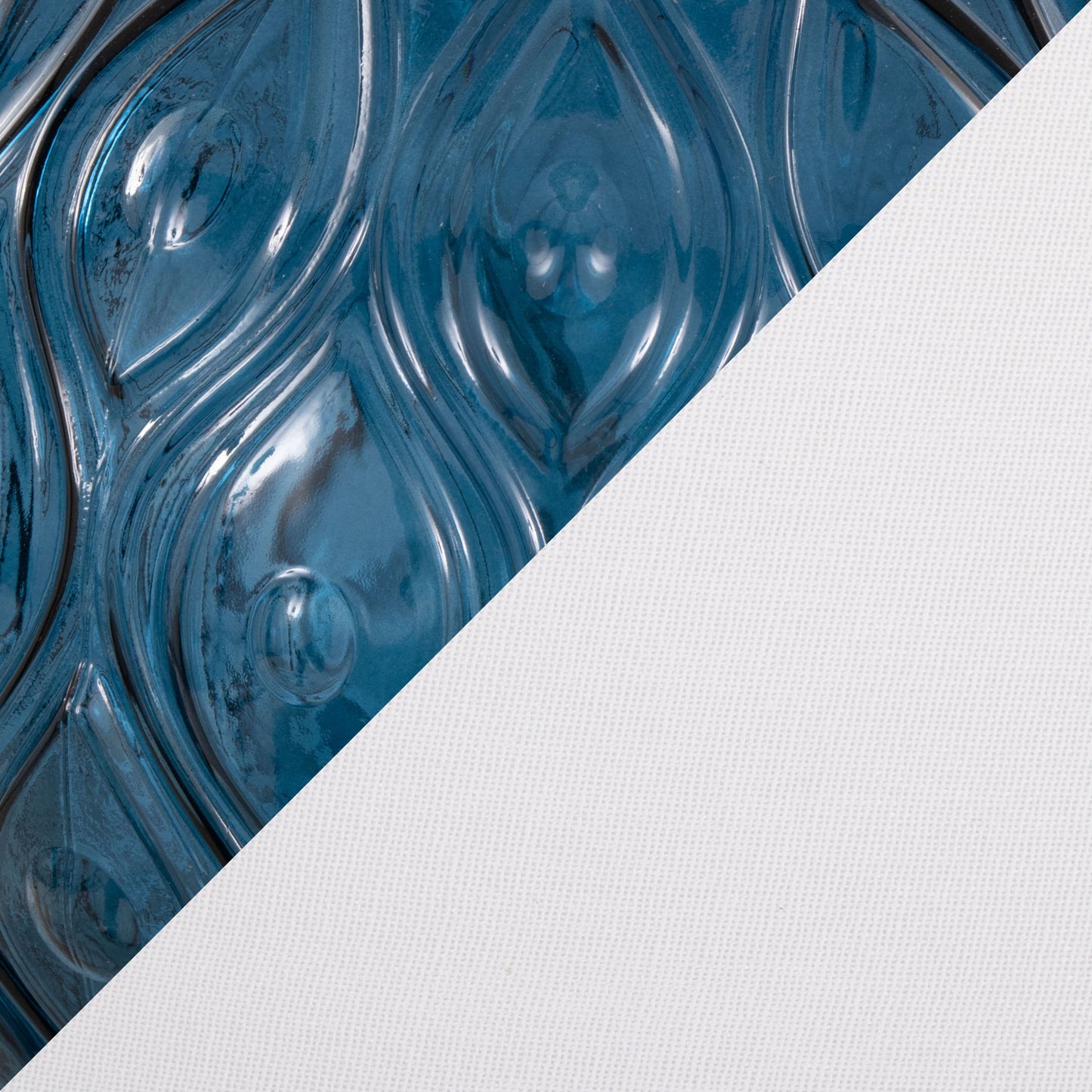 Close-up of a surface split diagonally; the left side shows glossy blue swirling teardrop patterns, while the right showcases textured white fabric, complementing the Gloria - Round Contemporary Lamp (Set of 2).