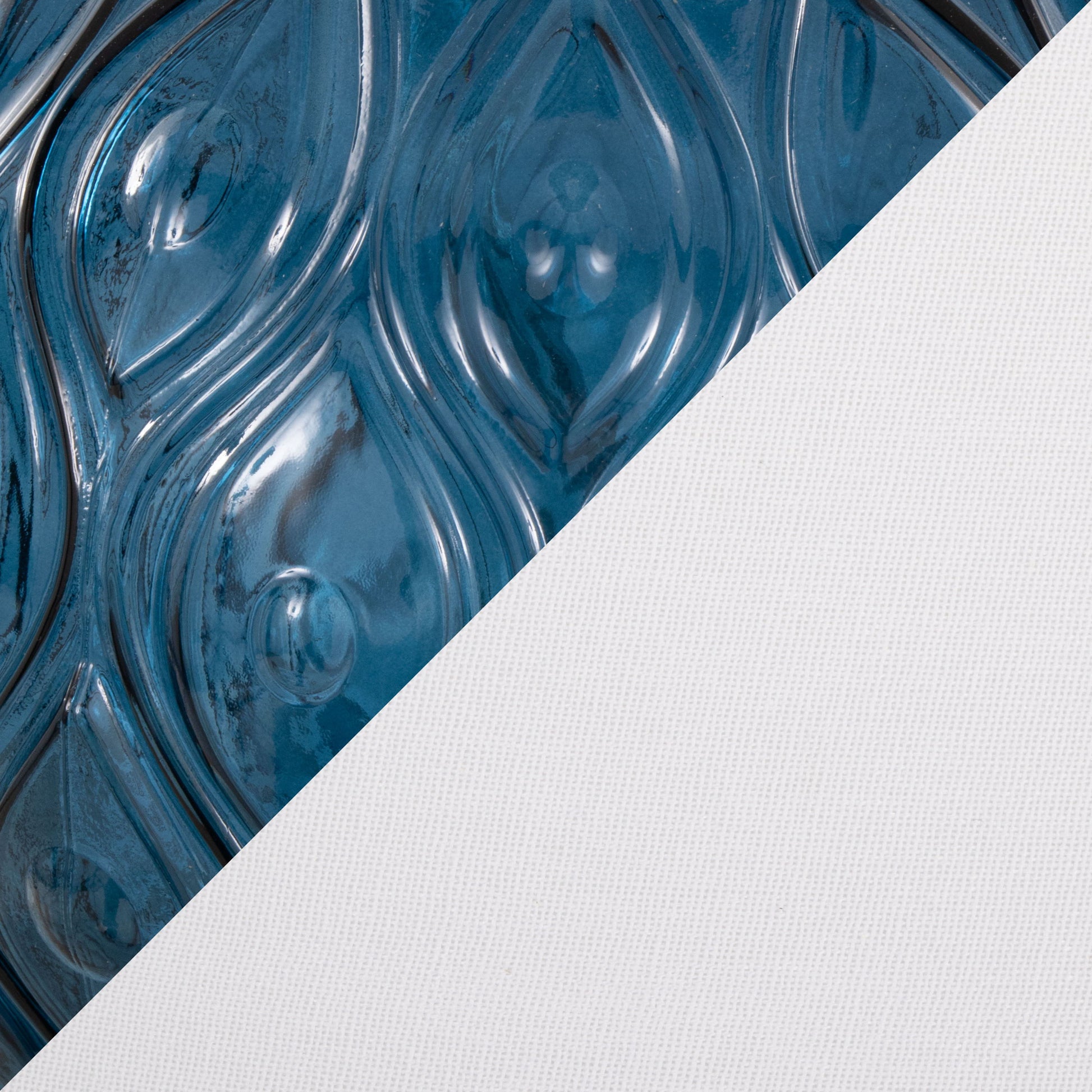 Close-up of a surface split diagonally; the left side shows glossy blue swirling teardrop patterns, while the right showcases textured white fabric, complementing the Gloria - Round Contemporary Lamp (Set of 2).