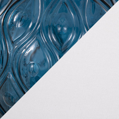 Close-up of a surface split diagonally; the left side shows glossy blue swirling teardrop patterns, while the right showcases textured white fabric, complementing the Gloria - Round Contemporary Lamp (Set of 2).