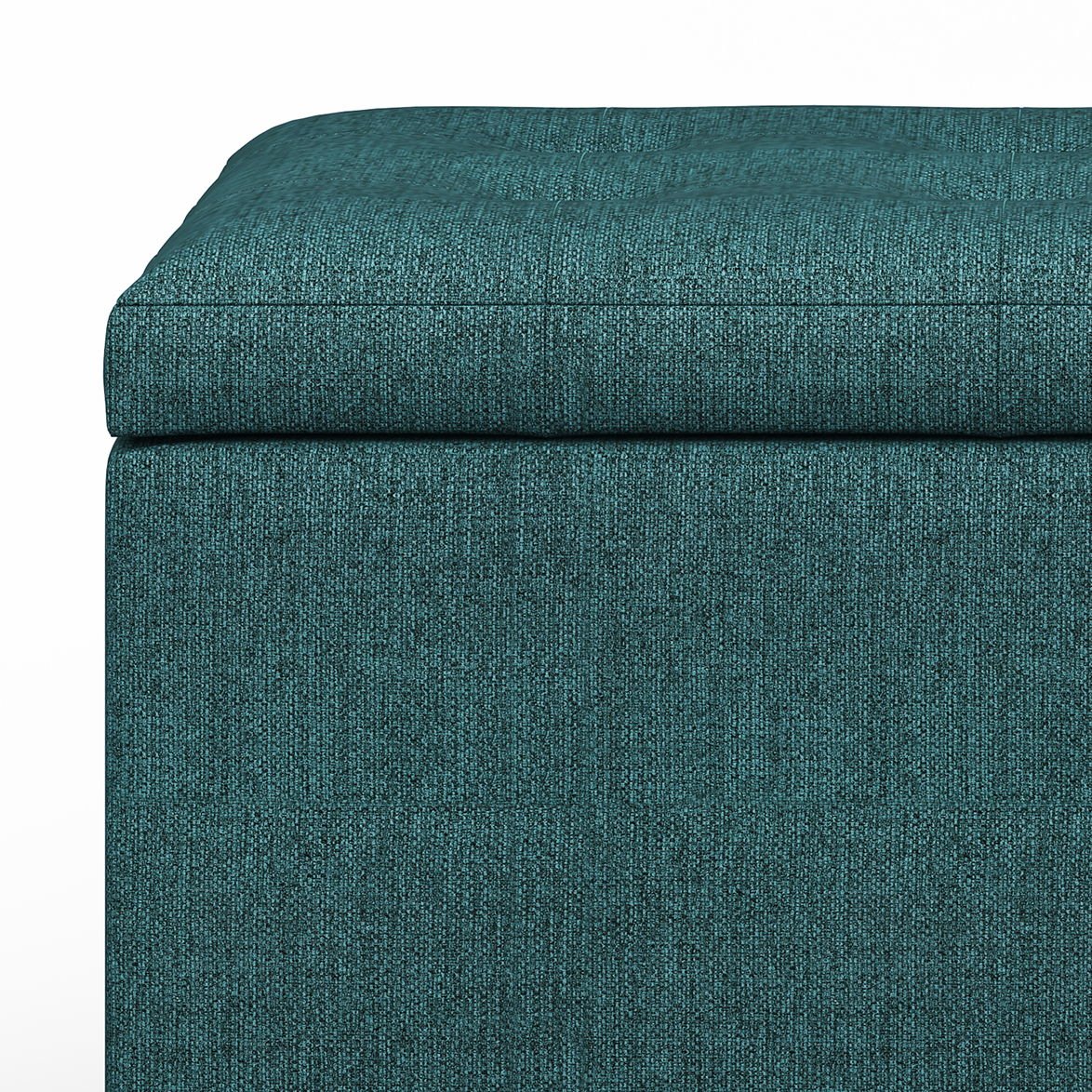 Close-up of the Cosmopolitan - Upholstered Storage Ottoman in teal, shown against a white background with detailed textured fabric, padded top, and visible stitching.
