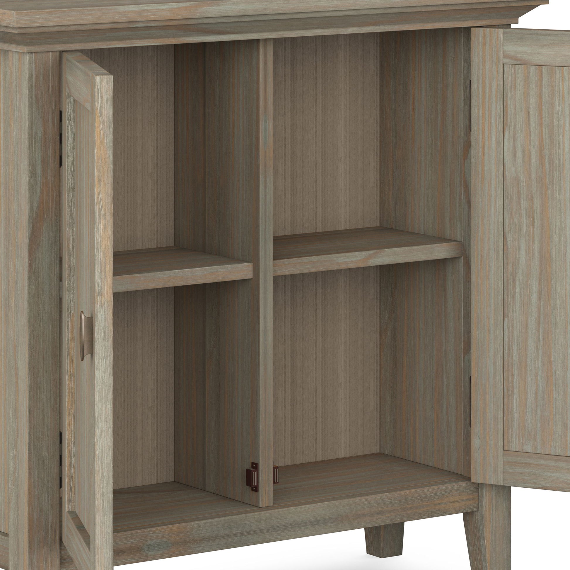 The Redmond - Handcrafted Low Storage Cabinet features two open doors revealing four storage spaces, formed by shelves dividing two vertical compartments. It is crafted from wood with a light, weathered finish.