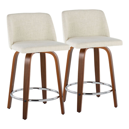 A pair of Toriano mid-century modern fixed-height counter stools with swivels, featuring light beige upholstered seats, curved wooden legs, metal footrests, and slightly angled backrests highlighted against a plain white backdrop.