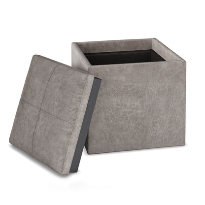 The Rockwood Upholstered Cube Storage Ottoman With Tray is shown in gray with its lid removed and propped against the side, revealing the empty storage compartment inside.