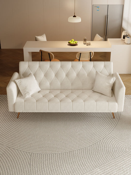 A modern, light living room features a Convertible Double Folding Living Room Sofa Bed with two white cushions, a textured circular rug, and a minimalist kitchen area with dining table, chairs, pendant light, and refrigerator in the background.