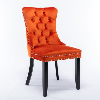 Set against a plain white background, the Nikki modern dining chair features high-end orange velvet upholstery, diamond-tufted backrest, silver nailhead trim, and four black wood legs.