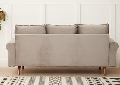 The Graceful Design Plush Comfort Sofa in light gray velvet, featuring three back cushions and wooden legs, sits against a white paneled wall with a black and white patterned rug partially visible on the floor.