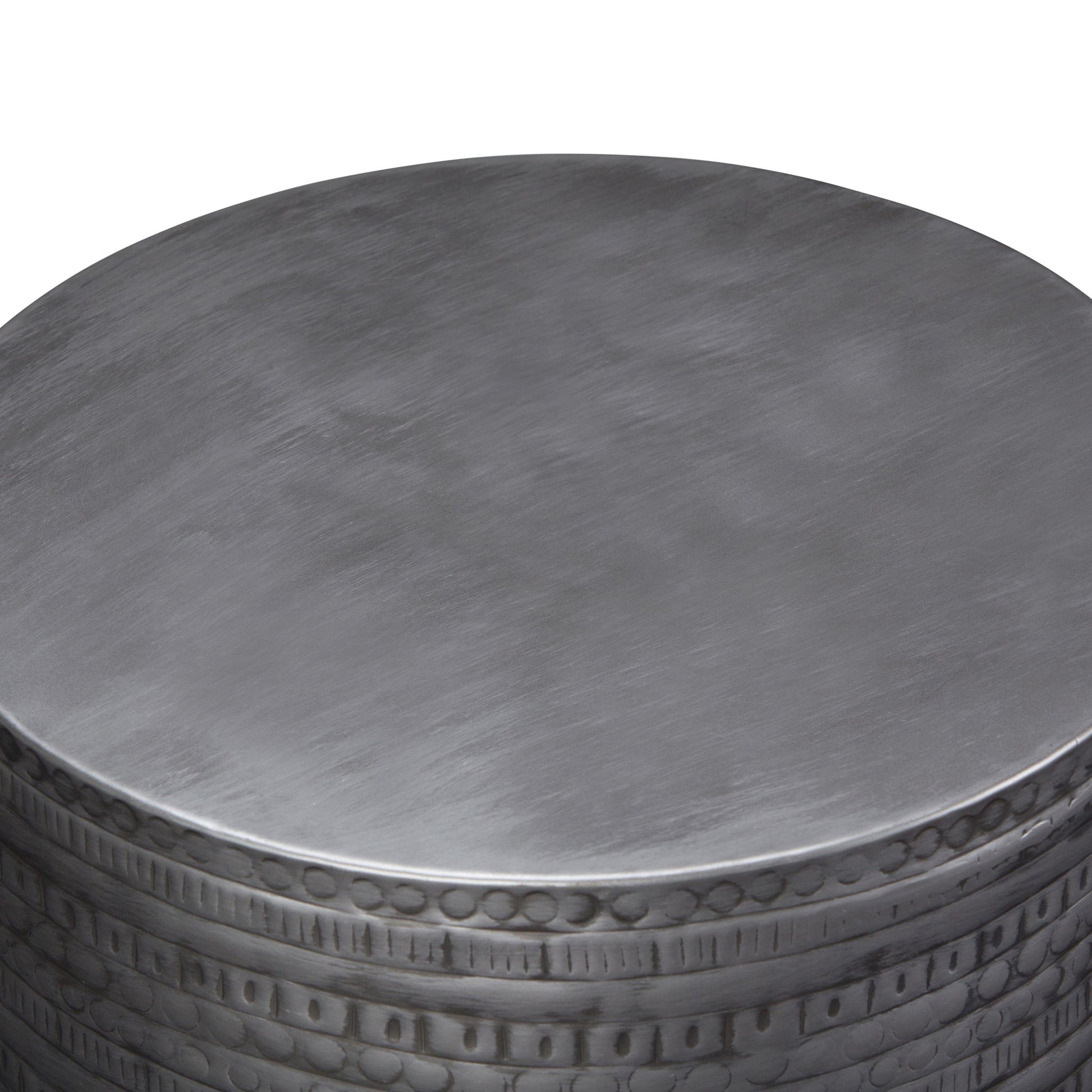 A close-up view of the Johnsen - Handcrafted Large Metal Accent Table, featuring a smooth round top and a decorative embossed edge.