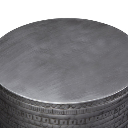A close-up view of the Johnsen - Handcrafted Large Metal Accent Table, featuring a smooth round top and a decorative embossed edge.