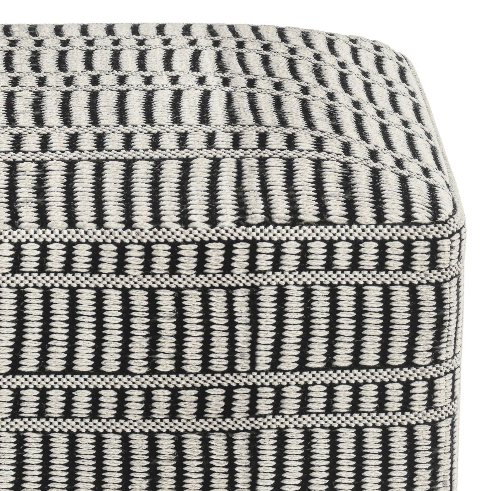 A close-up of the Safford Square Woven Outdoor/Indoor Pouf in black and white, showcasing its cube shape and bold striped woven pattern.