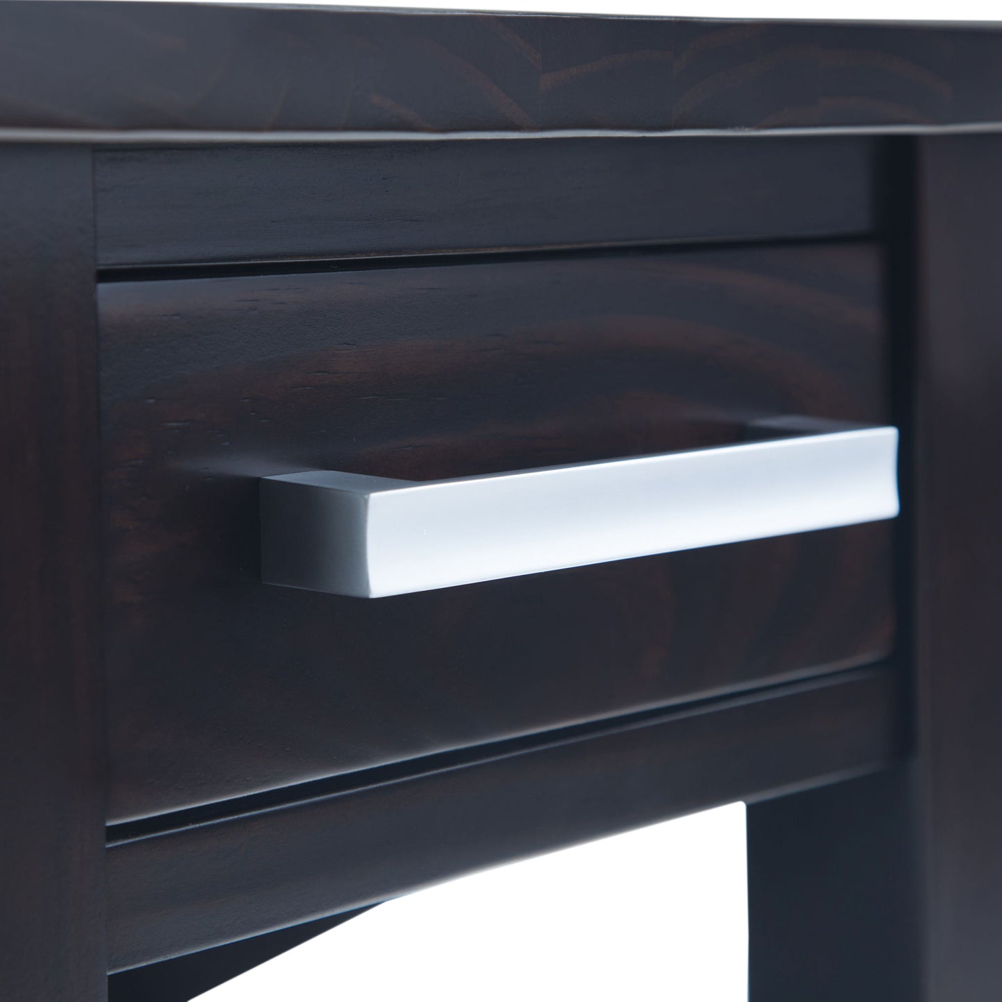 Close-up of the Kitchener - Handcrafted Table’s dark wooden drawer, highlighting its sleek, rectangular silver handle and part of the table’s elegant front.