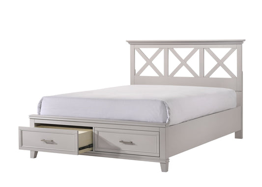 The X Ample Storage Bed features a light gray wooden frame, a geometric-patterned headboard, white bedding, and two foot-of-bed drawers—one open to display its ample storage space.
