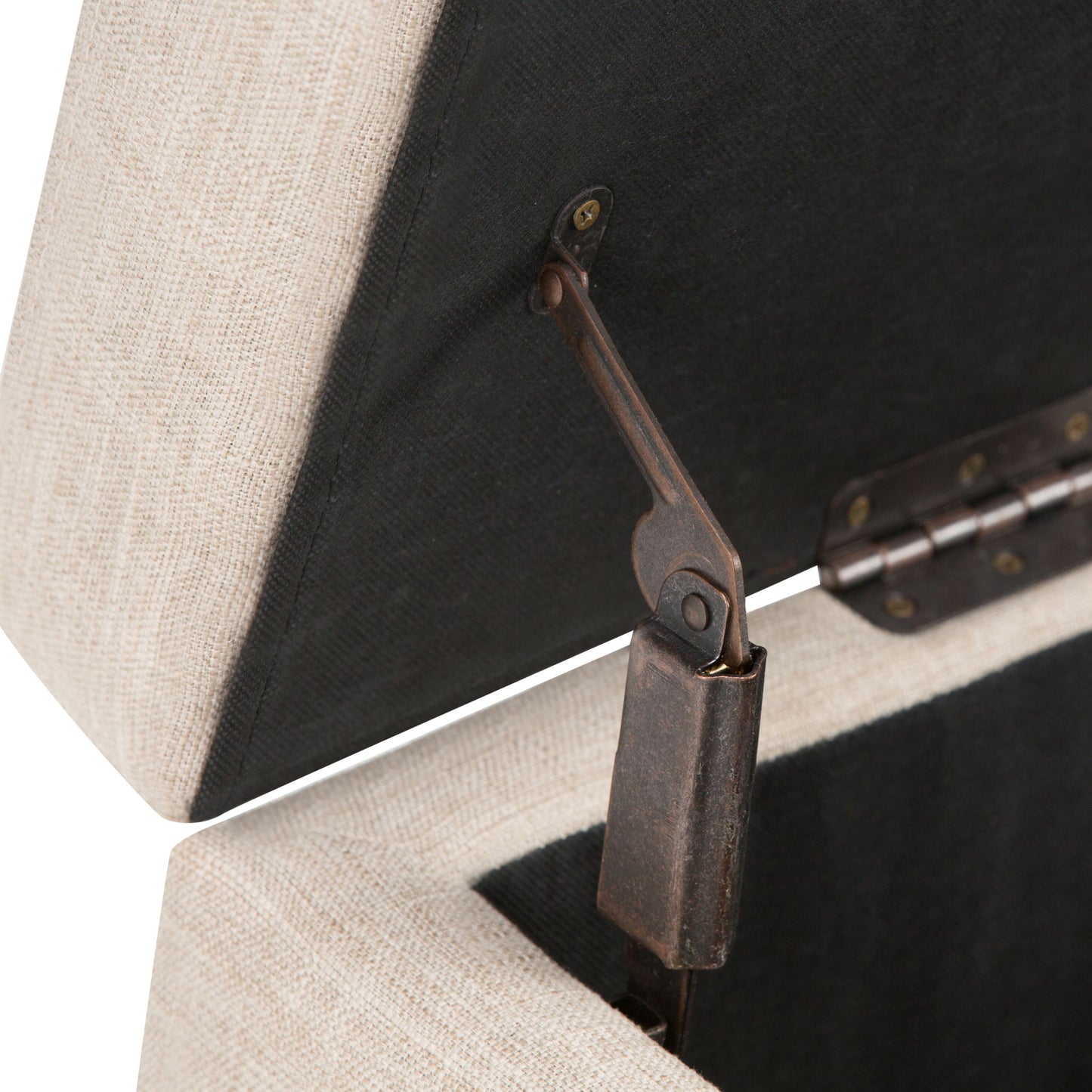 Close-up of the Hamilton - Upholstered Storage Ottoman in beige, featuring a partially open lid that reveals a black interior, metal hinge, and gas lift support mechanism inside.