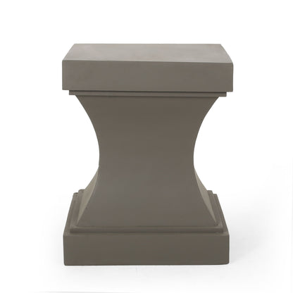 The Athena - Modern Side Table features a gray pedestal with a square top and base, an hourglass-shaped concave middle, and a smooth, modern finish. It is showcased against a plain white background.