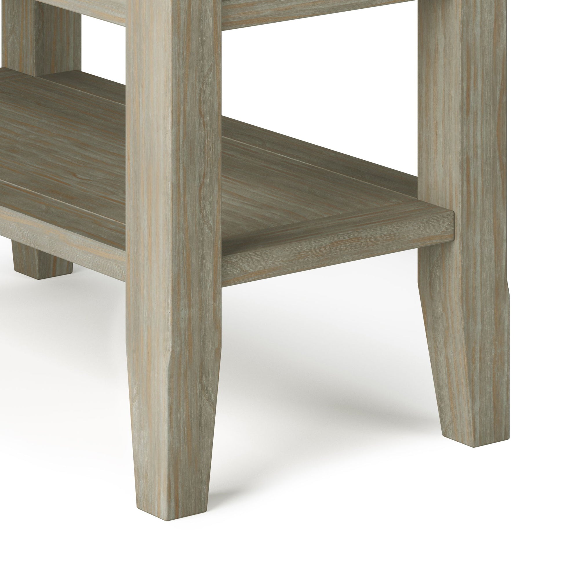 Close-up of the Acadian - Narrow Side Table, Handcrafted, showing its weathered light brown finish on smooth, straight-edged wood, four legs, and a lower shelf.