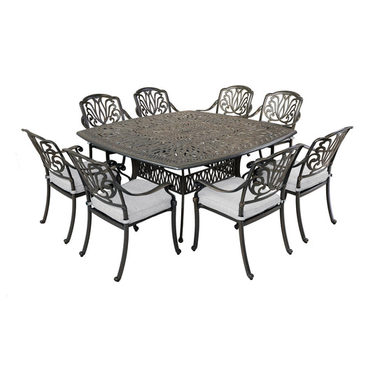 The Square 8 Person 64" Long Aluminum Dining Set With Cushions features an ornate metal lattice table and eight matching chairs, each with light-colored seat cushions—perfect for outdoor dining.