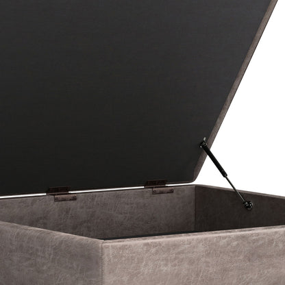 A detailed view of the Owen Multifunctional Square Coffee Table Storage Ottoman, featuring a hinged lid with gas lift support, revealing its spacious inner compartment and stylish textured gray upholstery.