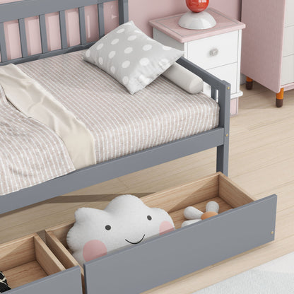 A tidy bedroom features a gray Pine Wood Daybed with two storage drawers, beige-striped bedding, a polka dot pillow, and a white nightstand. Under the daybed, a wooden drawer stores a smiling cloud pillow and a gray stuffed toy.