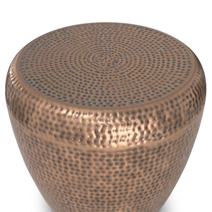 A close-up of the Preston Handcrafted Metal Side Table, showcasing its round shape, metallic hammered texture, and rich bronze finish.