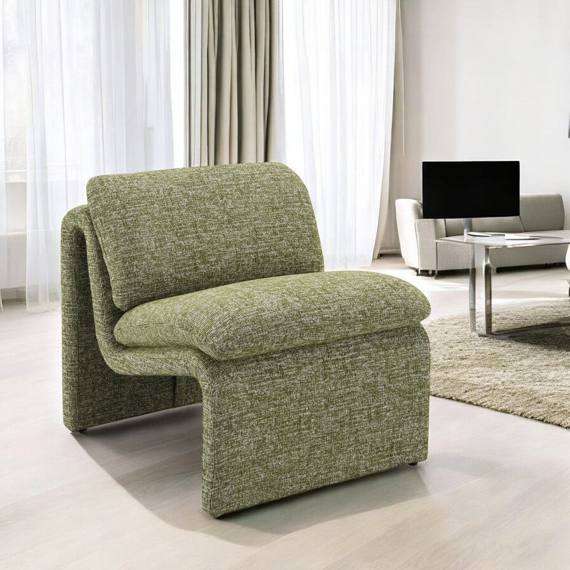The Jaeda - Innovative Elegance Accent Chair in a curved, modern green design sits on light wood flooring in a bright living room with sheer curtains and neutral-toned furniture.