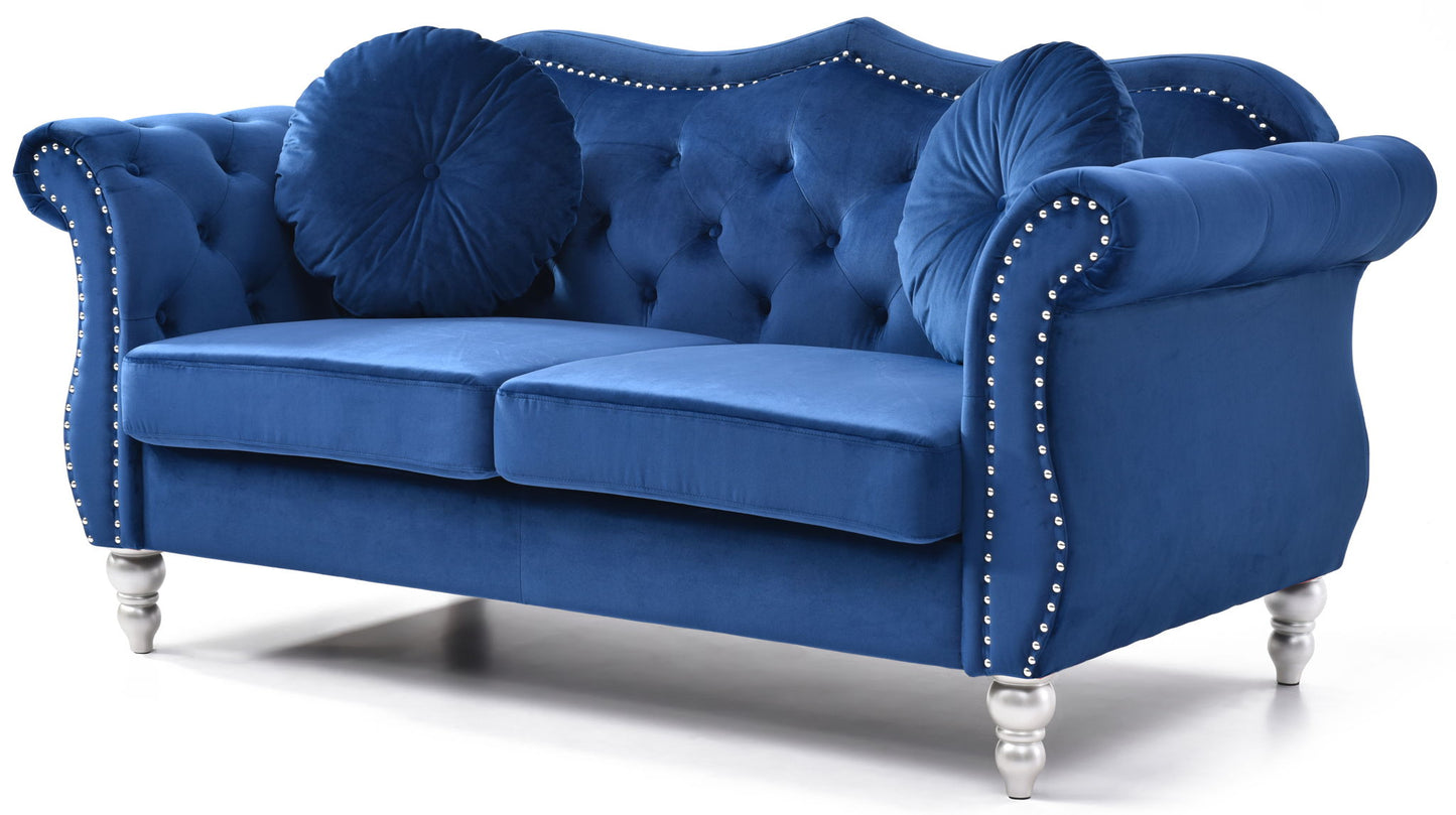 The Stylish Flared Arm Loveseat features royal blue velvet upholstery, a tufted backrest, silver nailhead trim, silver legs, and includes two matching round pillows, shown against a white background.