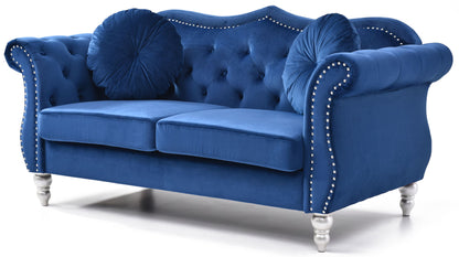 The Stylish Flared Arm Loveseat features royal blue velvet upholstery, a tufted backrest, silver nailhead trim, silver legs, and includes two matching round pillows, shown against a white background.