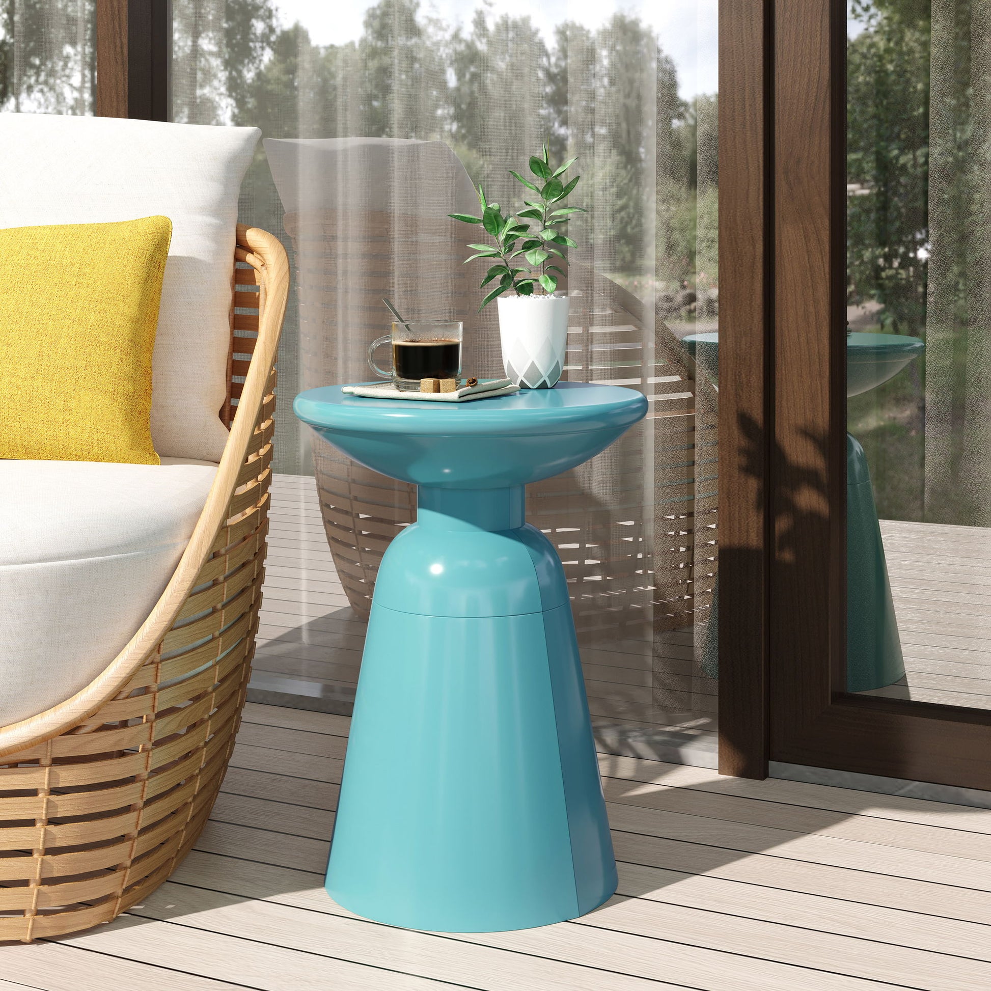 An Outdoor Modern Metal End Large Table holds a small potted plant and coffee cup beside a cushioned chair with a yellow pillow on a patio near glass doors with sheer curtains. Trees can be seen outside.