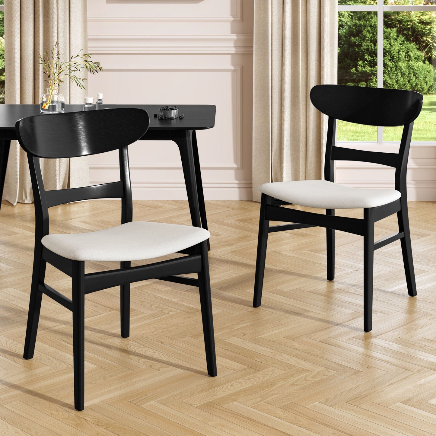 A set of two Mid Century Dining Chairs with cushioned seats and wood frames are placed on a herringbone floor in a bright room featuring beige curtains, large windows, and a black desk in the background.