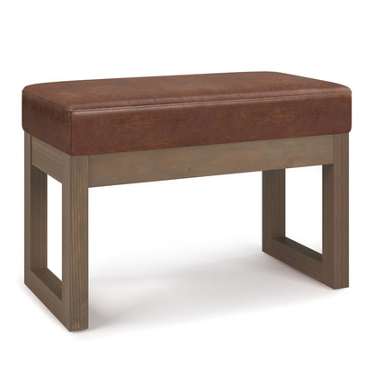 The Milltown - Upholstered Ottoman Bench features a brown cushioned seat, wooden legs, and an open rectangular frame, shown against a white background.