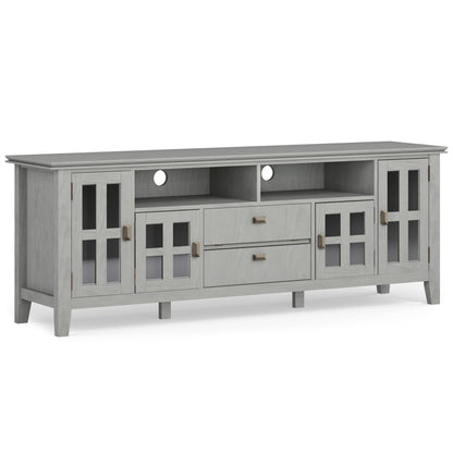 The Artisan TV Media Stand features a light gray wood finish, two glass-paneled side cabinets, two central drawers, two open shelves above the drawers, four legs, and rear cut-outs for cable management.
