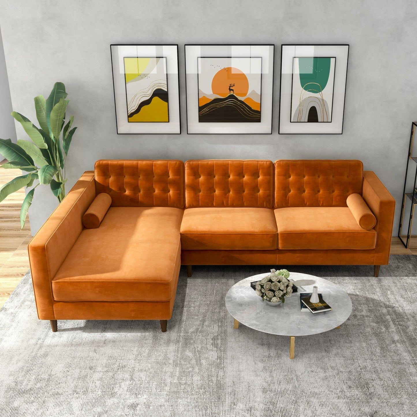 The Christian Mid-Century Modern Design Sectional Sofa in orange sits on a light rug beside a green plant. Three framed abstract prints hang on the gray wall above, and a round marble coffee table is in front of the sofa.