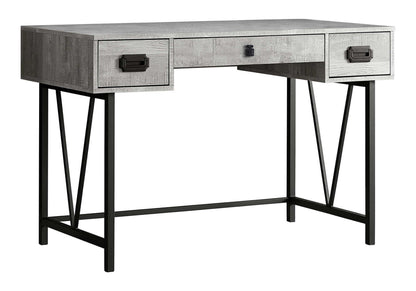 This transitional computer desk for home office or laptop use features a gray wood finish, three drawers with black handles, and black metal legs with angular supports for modern style and added storage.