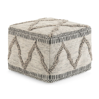 The Sweeney Upholstered Square Pouf features a beige woven fabric exterior with raised geometric patterns in a darker tan, showcasing zigzag and linear designs on its sides and top.