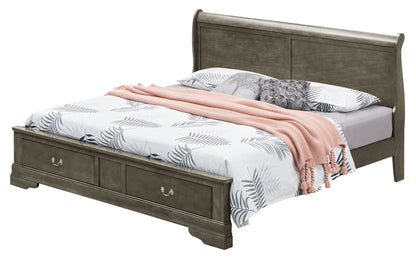The Louis Phillipe - Storage Bed features a gray wooden frame with storage drawers in the base, topped with white and leaf-patterned bedding, two pillows, a gray accent pillow, and a folded pink blanket.
