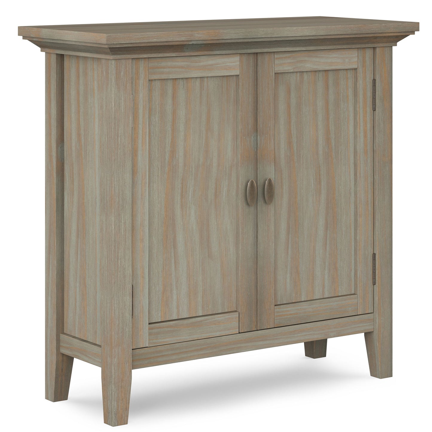 The Redmond Handcrafted Low Storage Cabinet features a distressed light brown wood finish, two doors with round handles, and four sturdy legs, shown against a white background.