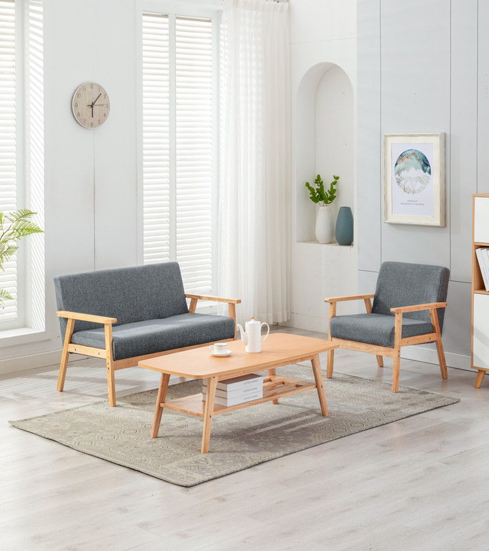 The Bahamas - Living Room Set features light wood floors, a gray loveseat, matching armchair, wooden coffee table, wall art, vases with greenery, and large windows with white blinds and sheer curtains for a modern look.