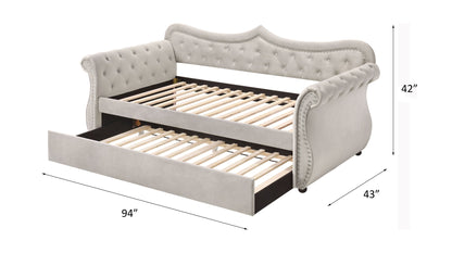 The Adkins Twin Daybed With Trundle in beige features a tufted upholstered design with a curved back and sides, pull-out trundle, black base, and wooden slats. Dimensions: 42” high, 94” long, 43” deep.