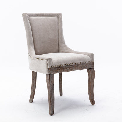 The Ultra Side Dining Chair features thickened beige fabric, neutrally toned solid wood legs, and bronze nailhead trim, presented against a plain white background. Set of 2.