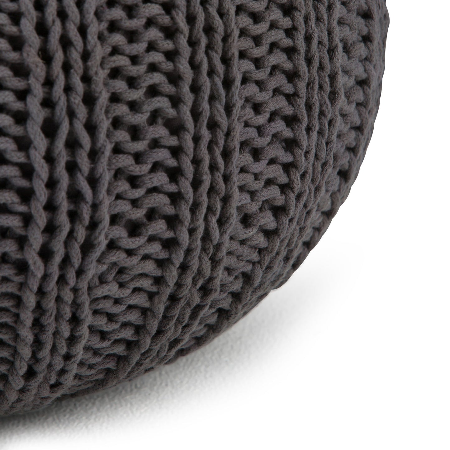 Close-up of the Shelby - Handcrafted Hand Knit Round Pouf in dark gray, featuring thick ribbed yarn texture, displayed on a white surface.