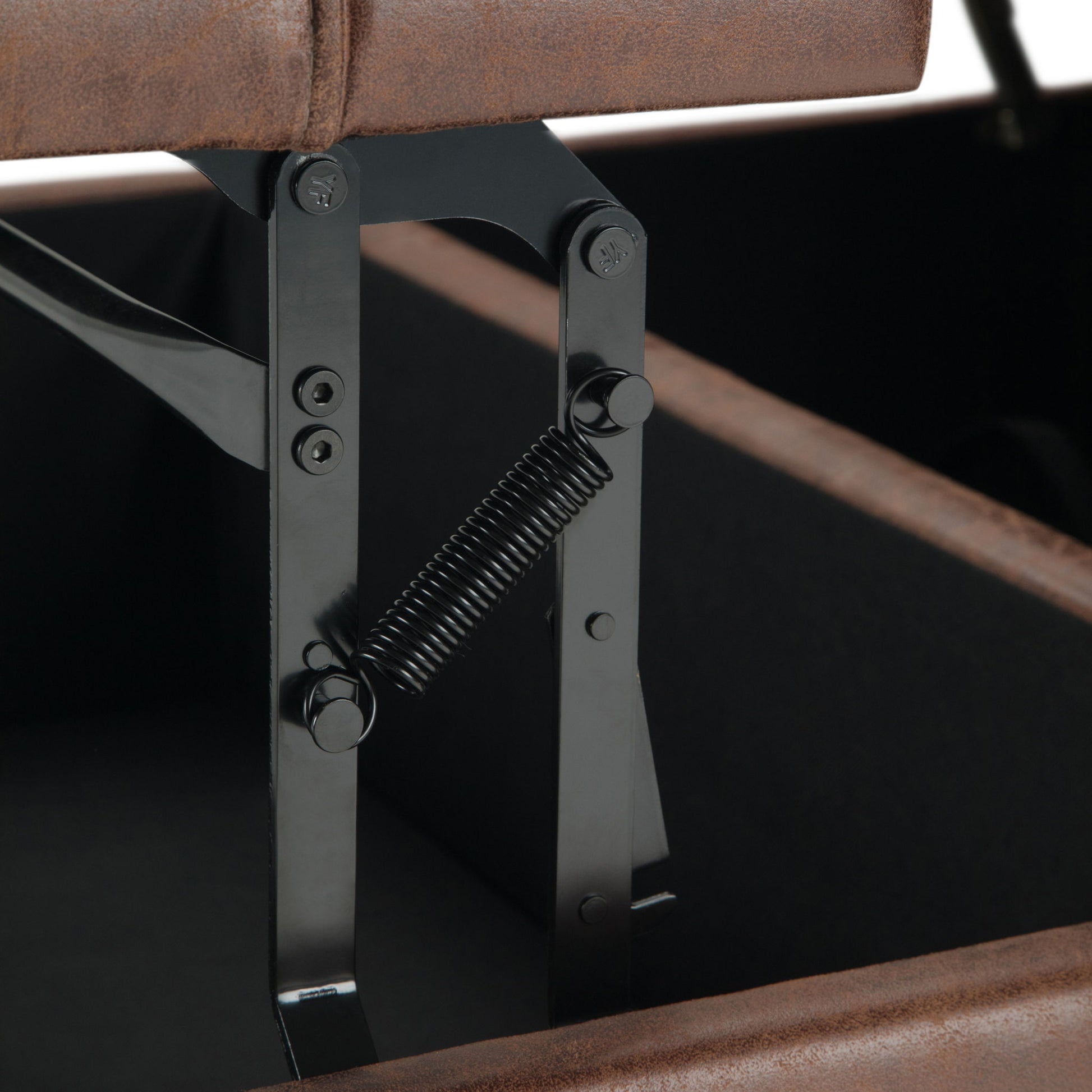 Close-up of the black metal hinge with spring inside the Harrison Upholstered Coffee Table Storage Ottoman, featuring a brown upholstered lift-up lid.