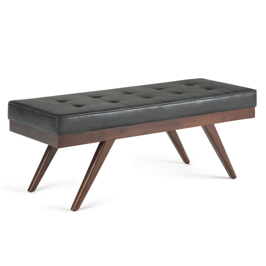The Pierce - Mid Century Upholstered Ottoman Bench features a black tufted cushion and angled wooden legs, showcasing a modern mid-century design.